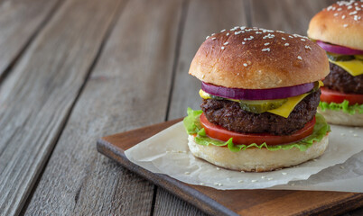 Burgers with meat, tomato, cucumber, cheese and onion. American cuisine. Fast food.