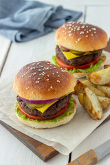 Burgers with meat, tomato, cucumber, cheese and onion. American cuisine. Fast food.