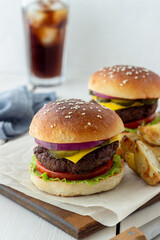 Burgers with meat, tomato, cucumber, cheese and onion. American cuisine. Fast food.