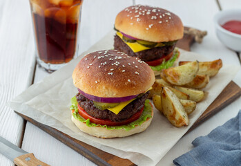 Burgers with meat, tomato, cucumber, cheese and onion. American cuisine. Fast food.