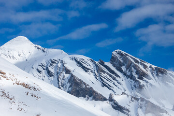 Fototapeta na wymiar Winter background with snowy mountains and blue sky.