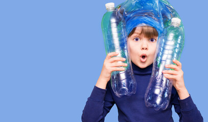 Girl hold trash bag and plastic bottle and shows interest in environmental issues isolated on blue...