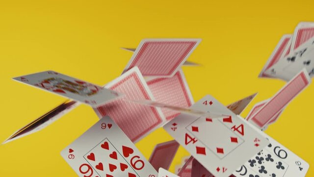 The deck of cards explodes in 4k UHD. Yellow background