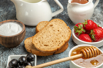 front view fresh strawberries with tea bread and honey on a dark background fruit sweet food