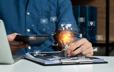 Hands holding a light bulb with digital network interface icons, Technology modern innovation of new creative ideas concept, Blue blurred background.