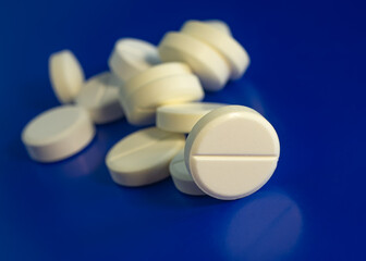 Pills lie on a blue background, close-up.