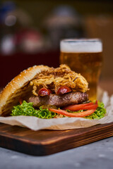  delicious burger with sausages and beer on a wooden board