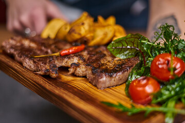 Beef steak with hot chili pepper on a wooden board