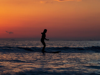 person surfboard on the beach at sunset