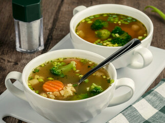 Homemade vegetable soup in a white bowl on a wooden table. Homemade Soup Day