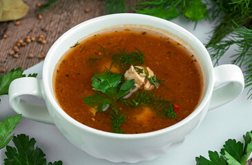 Homemade vegetable soup in a white bowl on a wooden table. Homemade Soup Day