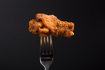 One Breaded Fried chicken wings on a fork with copy area © ejgrubbs