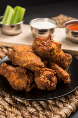 Spicy Deep Fried Breaded Chicken Wings with Blue cheese, hot sauce and celery condiments