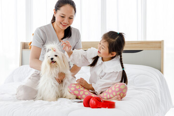 Asian mother and daughter with Maltese.