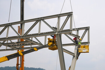 MALACCA, MALAYSIA -MARCH 12, 2020: Construction workers working at height at the construction site. They are supplied with harnesses and other safety equipment to prevent them from having an accident.