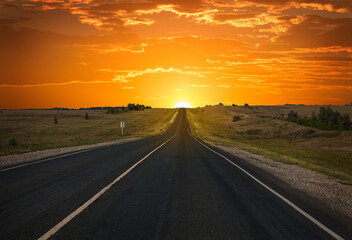 Sunrise on the horizon over an empty highway
