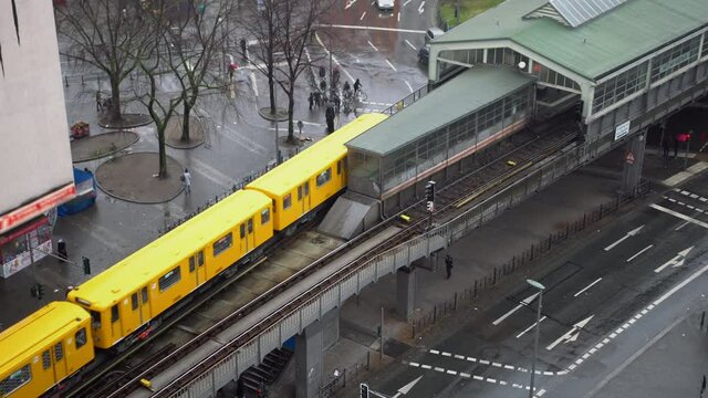 Yellow Public Transport Train exiting Subway Station elevated above ground at Kottbusser Tor in Berlin, Germany at Daytime