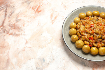 bottom half view roasted eggplant salad and pickled plums on plate on nude background free space