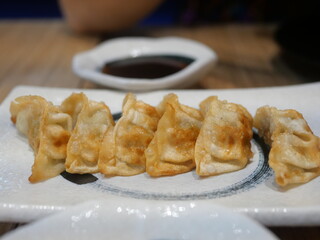 Gyoza (Japanese Fried Dumplings) is on a white plate. blur  background
