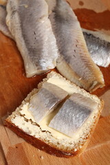 Sandwich with pickled herring and butter. Salted, soused skinless fillets of fish Clupea.