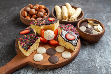 front view cake slices with nuts and cookies on dark background sweet cake dessert biscuit