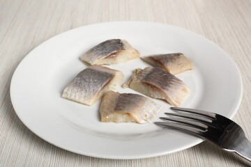 Pickled herring on plate. Salted, soused skinless slices of fish Clupea.