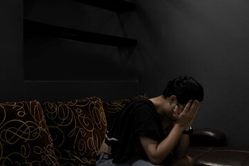 Fototapeta premium Sad young man sitting on the bed in the bedroom, People with depression concept.