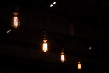 Close up incandescent orange light bulbs hanging in ceiling.