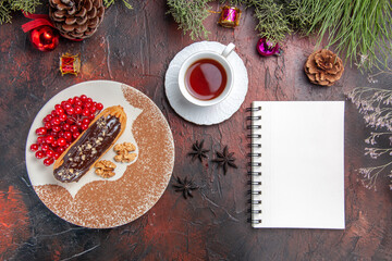 top view yummy choco eclairs with berries and tea on dark floor cake pie dessert sweet