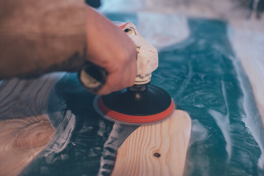 Man Polishing Epoxy Table. Epoxy Furniture