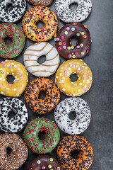 delicious assortment of donuts with icing and different fillings on a black background