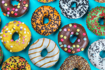 delicious assortment of donuts with icing and different fillings on a blue background