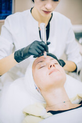 Naklejka premium young woman with problem skin receiving mesotherapy facial treatment in beauty clinic