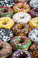 delicious assortment of donuts with icing and different fillings on the table. Background of doughnuts