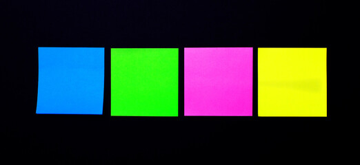 On a black background, bright self-adhesive stickers for notes. Place to insert text