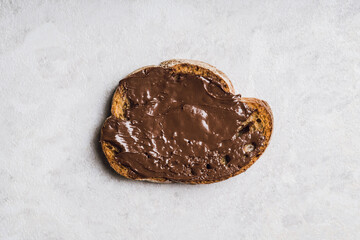 Slice of homemade bread with chocolate cream on the kitchen table for breakfast. Selective focus. Shallow depth of field.