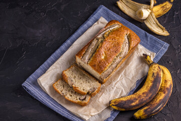 A traditional American dish is gluten and dairy free banana bread on a black concrete background. Top view, copy space.