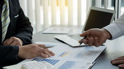 Image of business partners discussing on documents, graphs and ideas at a meeting of 2 businessmen.