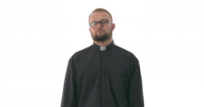 Close up portrait of Caucasian priest wiping forehead with hand. Expressing relief. Isolated on white background