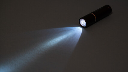 Flashlight and a beam of light in the dark. Flashlight ray in the darkness. Torchlight in the...
