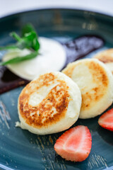 cottage cheese pancakes close-up, healthy breakfast, restaurant serving, on a turquoise plate