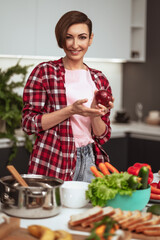 Housewife prepares dinner for family choosing a vegetables holding a red onion in a hands standing in the kitchen. Healthy food at home. Healthy food leaving concept.