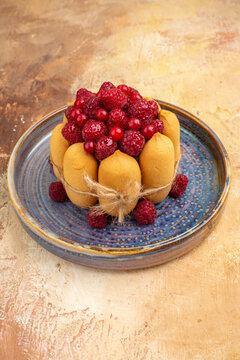 Vertical view of freshly baked gift cake with fruits on a blue trayon mixed color table footage