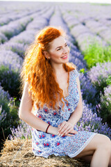 Summer portrait of a beautiful girl with long curly red hair. European girl in lavender field. Wavy Red Hair
