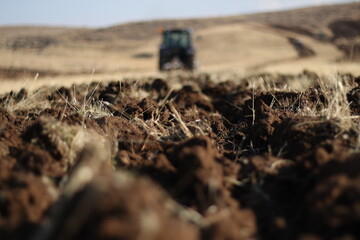 Tractor plows a field. Agricultural work in processing, cultivation of land. Farmers preparing land and fertilizing. Agricultural workers with tractors