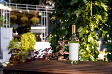 Drink, alcohol concept - Wine bottle on wooden table of restaurant terrace. Blank label for your text or logo.