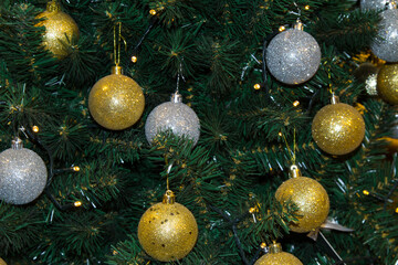 Close-up of a Christmas tree with gold and white shiny balls. Christmas background.