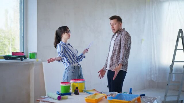 misunderstanding and quarrel in family relationships, young couple argues about the color of the walls in their new home during renovation
