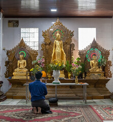 Croyant à genoux priant dans un temple à Yangon, Myanmar