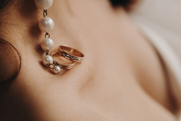 Wedding rings lie beautifully on the girl's collarbone